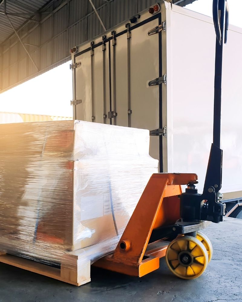 Załadunek zafoliowanej palety drewnianej HGV wózkiem paletowym na naczepę - dostawa dla firm ze Zduńskiej Woli