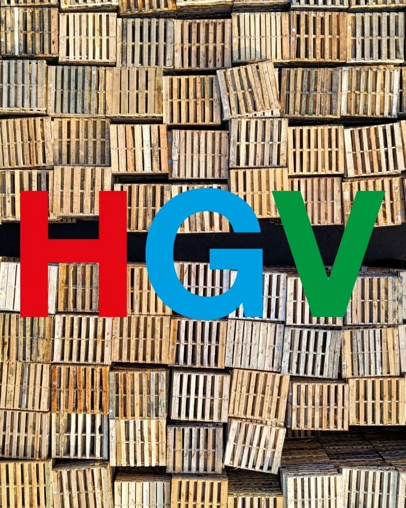 Logo firmy HGV na tle setek palet drewnianych ułożonych w stosy – producent palet