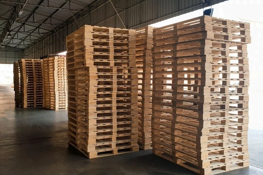 Stos nowych palet drewnianych w magazynie producenta HGV Leszno